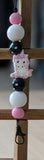 Keychain with colorful beads and a cartoon character on a wooden cross