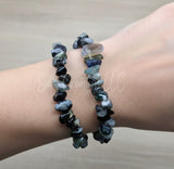 Two handcrafted stone chip bracelets made of black Obsidian and miscellaneous stones worn stacked on a person's wrist.