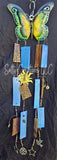 Butterfly-shaped wind chime with blue and brown elements on a dark background
