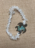 A bracelet made with white beads and a label that says 'Salty' in a teal font.