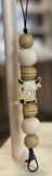 Wooden freshie hanger with character design on a blurred background
