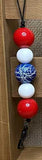 Colorful bead keychain with red, white, and blue beads on a wooden surface.