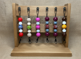 Wooden keychain holder with colorful keychains on a textured beige background