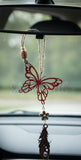 Red butterfly car hanging ornament on a car's rearview mirror.