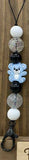 Beaded lanyard with teddy bear charm on a wooden surface