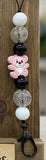 Keychain with teddy bear charm and beads on a wooden background