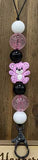 Decorative keychain with colorful beads and a teddy bear charm on a wooden background