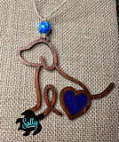 Handmade wooden dog silhouette car charm with a blue heart inlay, and blue marble like acyrlic bead on burlap background