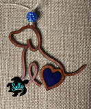 Handmade wooden dog silhouette car charm with a dark blue heart inlay, and blue acyrlic bead on burlap background