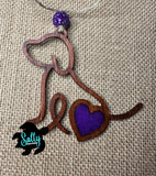 Handmade wooden dog silhouette car charm with a purple heart inlay, and purple acyrlic bead on burlap background