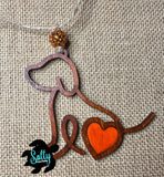 Handmade wooden dog silhouette car charm with a orange heart inlay, and orange acyrlic bead on burlap background