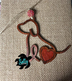 Handmade wooden dog silhouette car charm with a red inlay, and red acyrlic bead on burlap background
