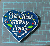 Heart-shaped patch with 'Stay Wild Gypsy Soul' text on a cutting mat