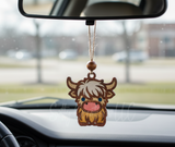 Handmade wooden Highland Cow car charm with a rustic wood bead, hanging from a rearview mirror by tan twine inside a car.