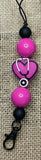 Hanger with fuscia and black beads on a textured background
