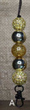 Beaded lanyard with gold and silver beads on a brown background