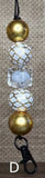 Beaded keychain with gold and white beads on a textured background