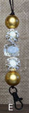 Beaded keychain with gold and clear beads on a textured background