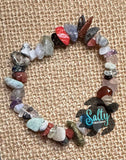 A multicolored beaded bracelet with a variety of shapes and colors, displayed on a textured background.