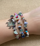 Handcrafted stackable gemstone chip bracelets by Salty Creations, LLC, displayed on a wrist against a neutral burlap background.
