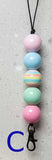 Colorful beaded keychain with a black cord on a light gray background