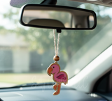 Pink flamingo car hanging ornament on a car's rearview mirror.