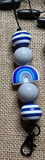 Freshie Hanger with blue and white beads on a textured surface