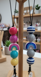 Colorful beaded freshie hanger on a wooden stand with a blurred indoor background