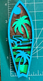 A wooden magnet with a tropical classic car surfboard design, blue, placed on a measuring mat.