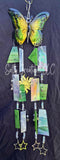 Butterfly wind chime with colorful hanging elements on a dark background
