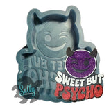 Decorative item with a smiling devil face and 'Sweet But Psycho' text on a white background.