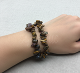 Hand wearing a stonechip bracelet on a light gray background
