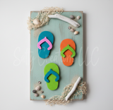 Decorative magnet with colorful flip-flops and beach elements on a light background