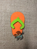 Orange and Lime Green Wooden flip flop magnet on a burlap background.