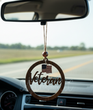 Decorative car hanging with 'Veteran' and American flag in a car dashboard.