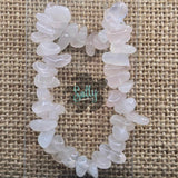 A bracelet made of rose quartz stones, displayed on a textured background.