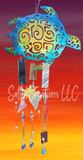 Decorative wind chime with turtle design against a colorful sunset background