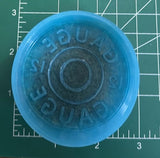 A silicone mold for making 12-gauge shotgun shell vent clips on a measuring mat. 