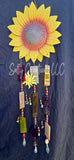 Decorative sunflower wind chime with beads against a dark background