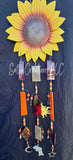 Decorative sunflower wind chime with hanging charms on a dark background